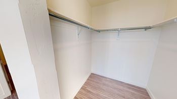 A room with a white wall and a wooden floor.